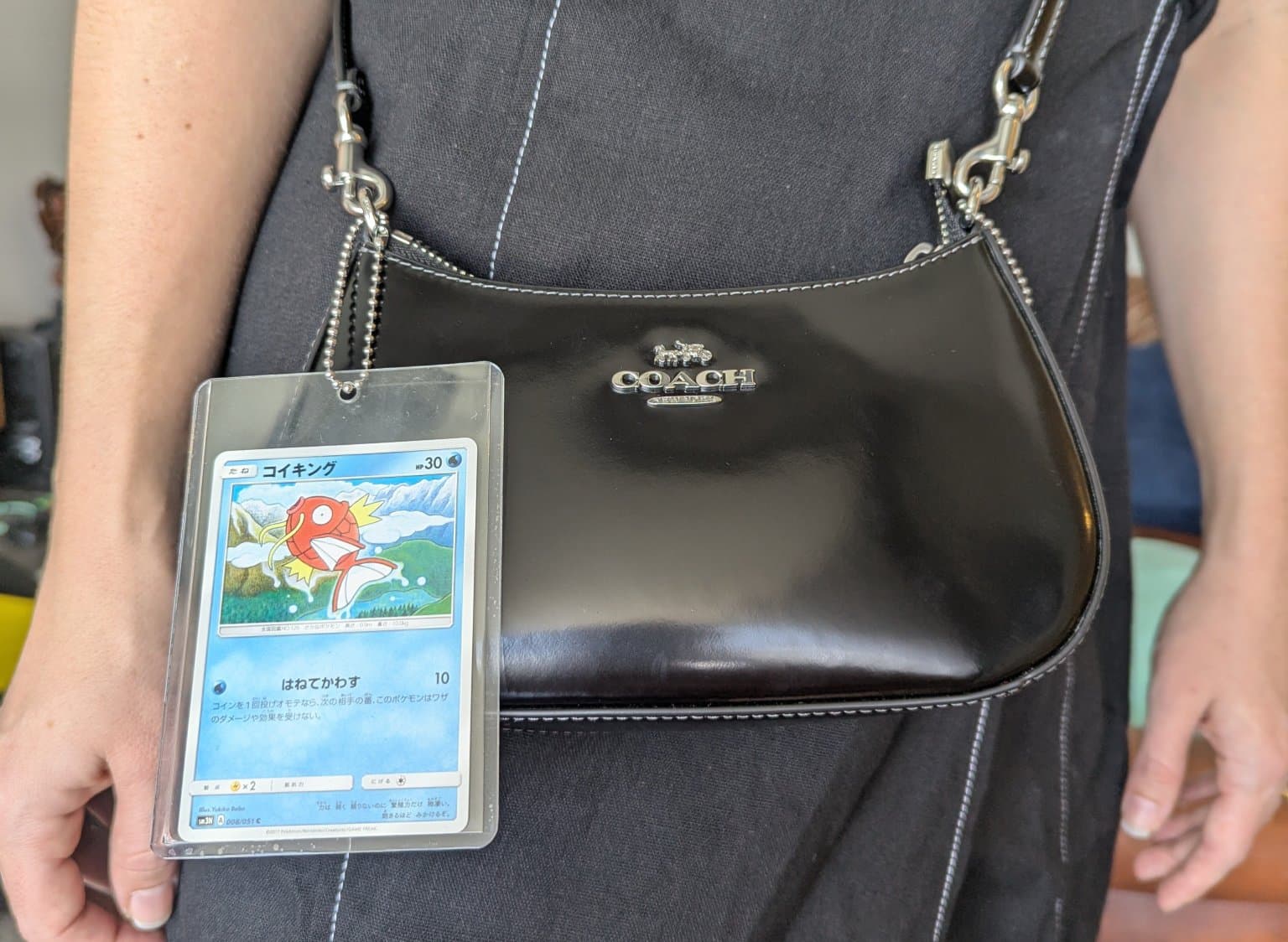 A Bulbasaur hanging off a Coach handbag.