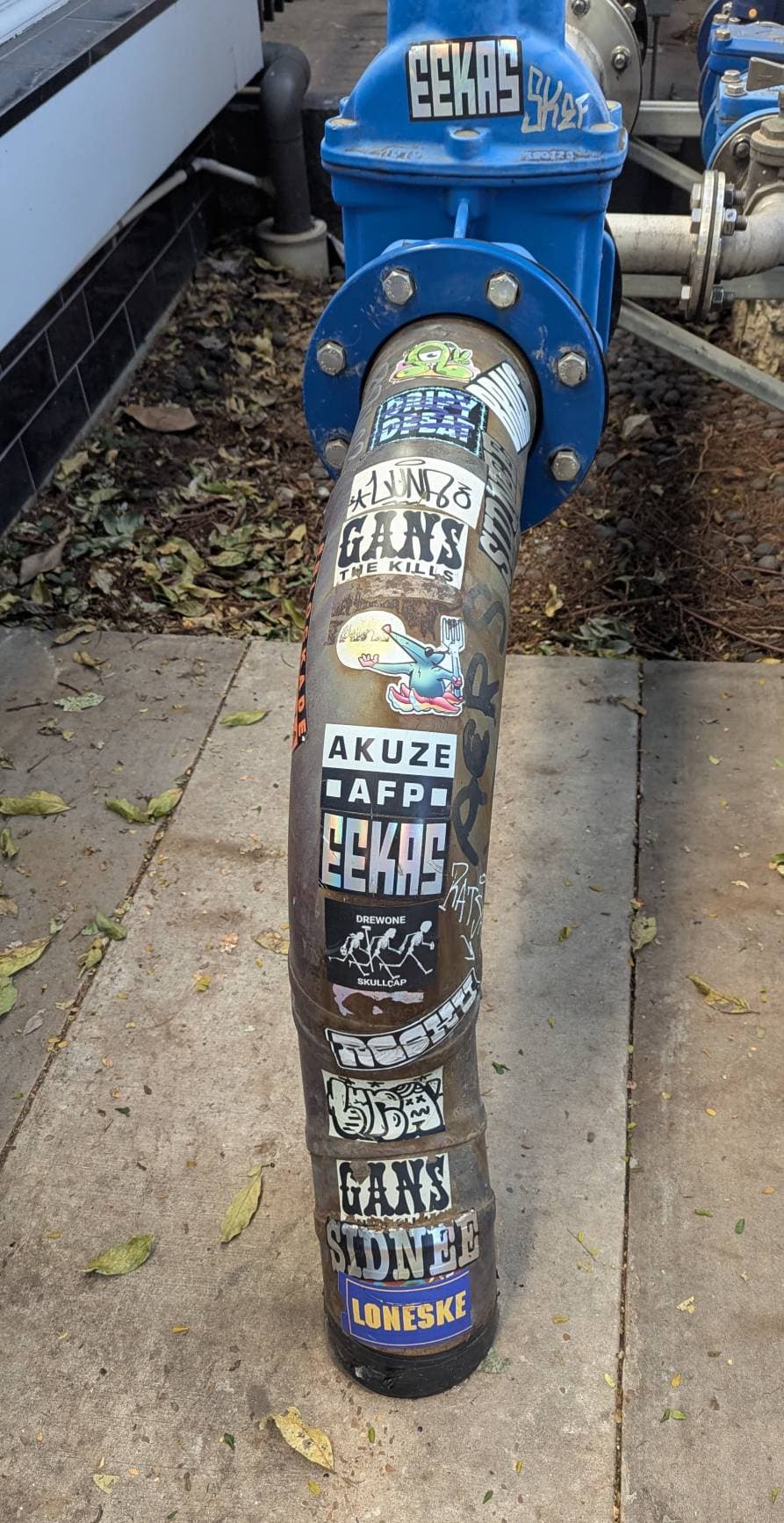 A pipe covered in stickers, including a Holographic Eekas sticker.